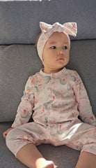 Baby girl wearing pink fairy print organic cotton sleepsuit with snaps brand Duper DuDu design by a NICU nurse