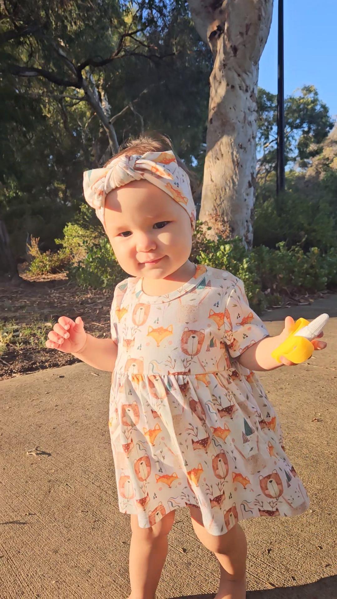 Baby girl wearing Wild Team organic cotton bow accessory with the dress set
