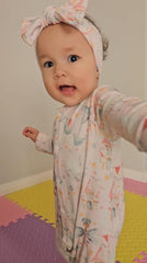 Baby girl wearing pink fairy print organic cotton sleepsuit with snaps brand Duper DuDu design by a NICU nurse