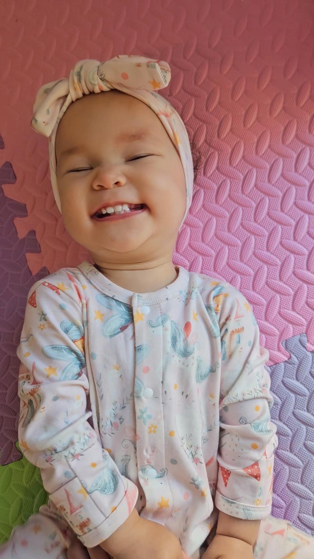 Baby girl wearing pink fairy print organic cotton sleepsuit with snaps brand Duper DuDu design by a NICU nurse