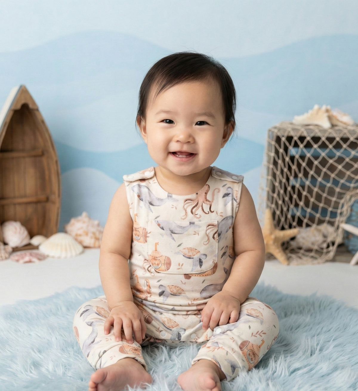 Baby wearing sleeveless organic cotton romper playing in summer