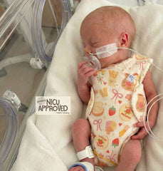 Premature baby sleeping in NICU incubator wearing Bakery Dreams organic romper. Design allows easy access for medical wires and feeding tubes. NICU Approved. Duper DuDu